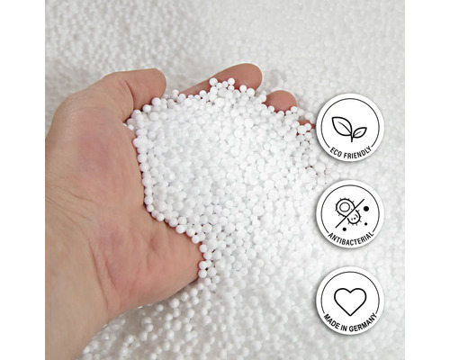 Hand håller fyllnadsmaterial av vita kulor med sigillen: Miljövänlig, Antibakteriell och Tillverkad i Tyskland.