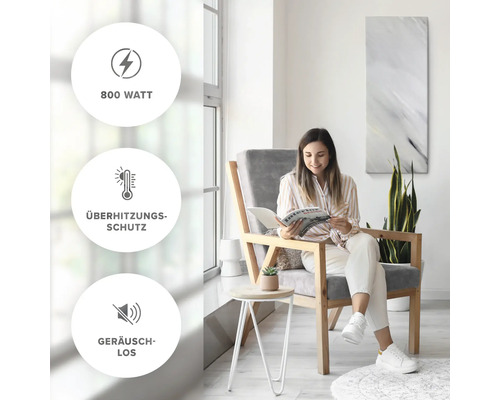 Kvinna läser i ett ljust rum. Produktegenskaper: 800 watt, överhettningsskydd, tyst