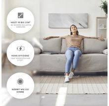 Vardagsrum med kvinna som sitter på soffan framför en väggmonterad värmepanel