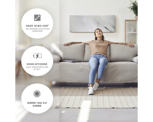 Vardagsrum med kvinna som sitter på soffan framför en väggmonterad värmepanel