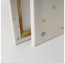 Närbild av två canvastavlor med stjärnmönster och träram.