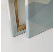 Närbild av två canvastavlor med abstrakta bergmotiv och träram