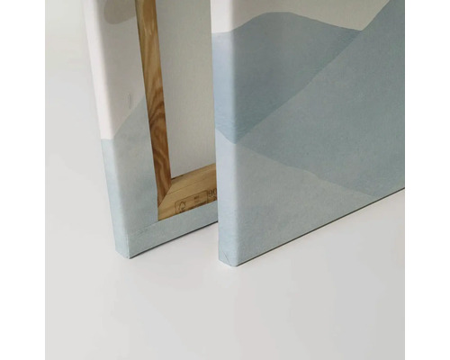 Närbild av två canvastavlor med abstrakta bergmotiv och träram