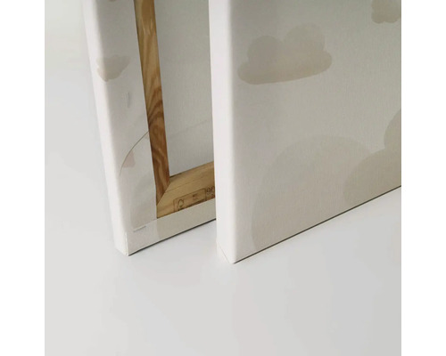 Detaljvy av två dukar med molnmotiv och träram