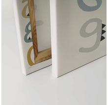 Närbild av två canvastavlor med bokstäver och träram