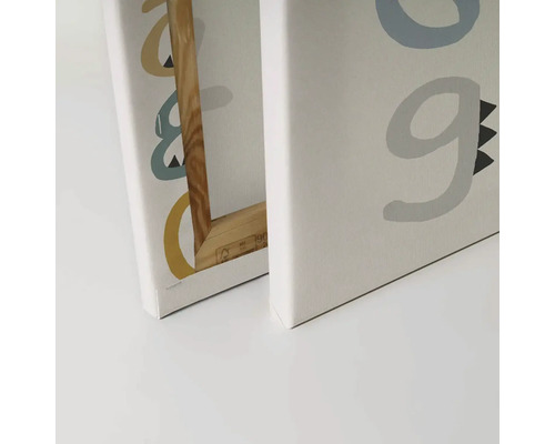 Närbild av två canvastavlor med bokstäver och träram