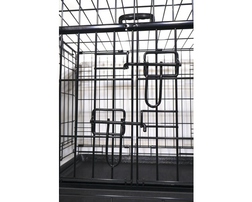 Detaljvy av en svart hundbur med dörrlås.