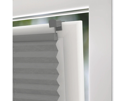 Grå plisségardiner på fönstret med fäste för ljusreglering