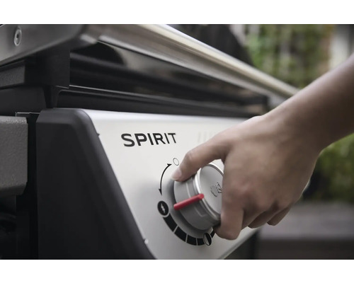 Närbild av en Spirit gasolgrill med en hand på kontrollratten.