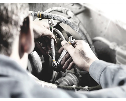 Mekaniker med skiftnycklar reparerar en motor