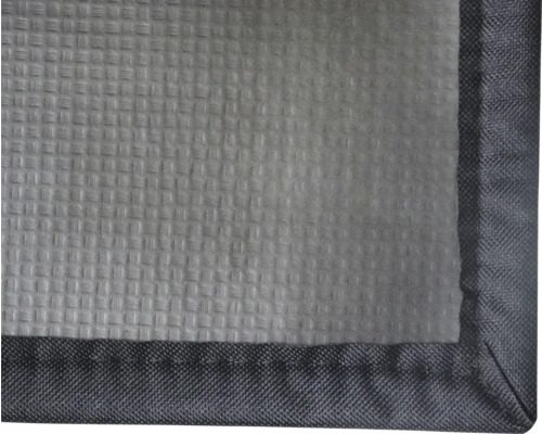 Detalj av textil med strukturerad yta och kantförslutning