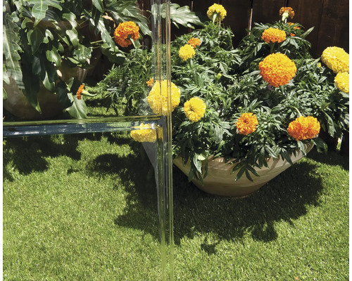 Scen med blomlådor och glaselement i trädgården