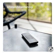 En platt fjärrkontroll med kontrollknappar ligger på ett bord i ett vardagsrum. (Image AI modified or generated)