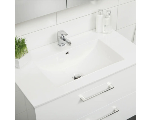 Tvättställ med blandare och lådor i badrum.