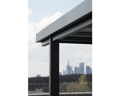 Detaljvy av ett altantak av metall framför en stadssiluett