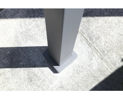 Detaljvy av en grå terrassöverdragstolpfäste på betonggolv.