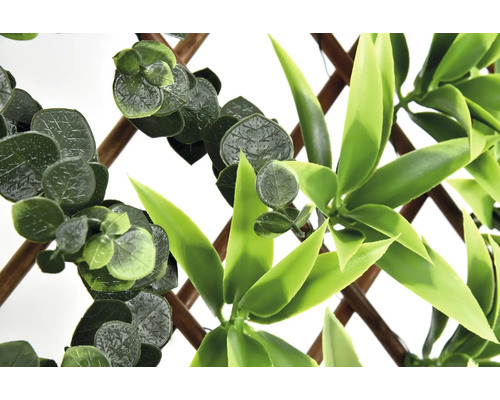 Konstgjord växtvägg med eukalyptus och bambublad på trägaller