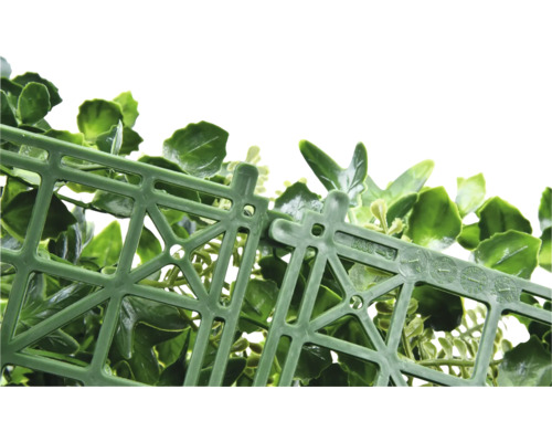 Detaljvy av en grön, konstgjord häck med ett plastgaller som bärarmaterial.