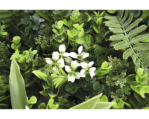 Konstgjord växtvägg med olika gröna blad och vita blommor.