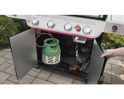 Gasolgrill med öppna skåpdörrar, gasoltub och grilltillbehör