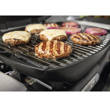 Grill med grillad mat, inklusive hamburgare med ost och lök