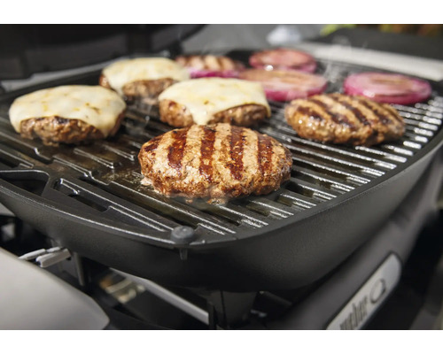 Grill med grillad mat, inklusive hamburgare med ost och lök