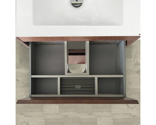 Öppet tvättställsskåp med låda och fack under ett handfat.