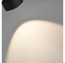 Svart vägglampa med ljuskägla