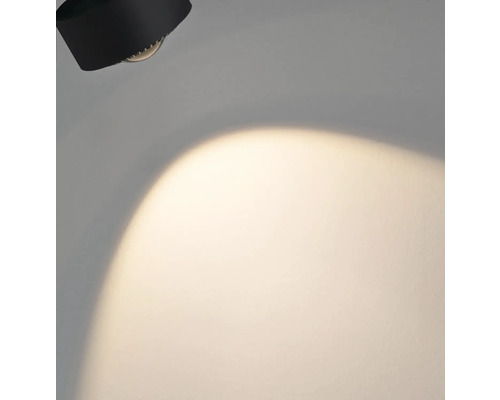 Svart vägglampa med ljuskägla