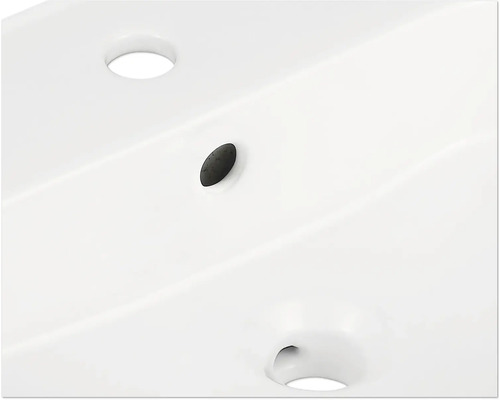 Detaljvy av ett tvättställ med kranhål och överfyllnadsskydd