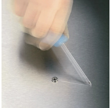 En person applicerar lim på en skruv