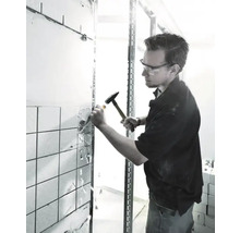 Man tar bort kakel med hammare och mejsel vid renoveringsarbete