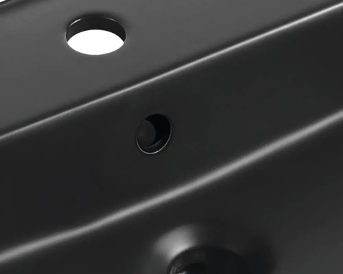 Detaljvy av ett tvättställ med kranhål och överlopp