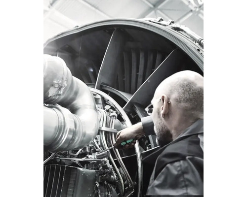 En mekaniker underhåller en flygplansmotor.