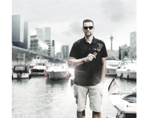 Man med insexnyckelsats framför en hamn