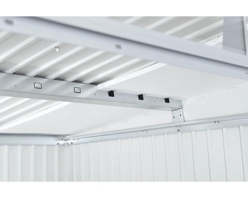 Detaljvy av metallkonstruktion och takisolering av ett trädgårdshus.