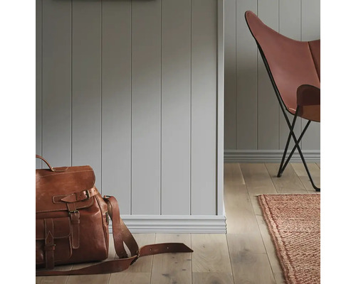 Rumsöversikt med väggpaneler, läderstol, matta och läderväska