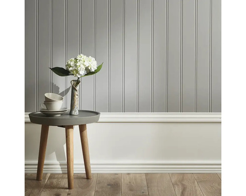 Väggpaneler med vit sockel, bord med vas och porslin