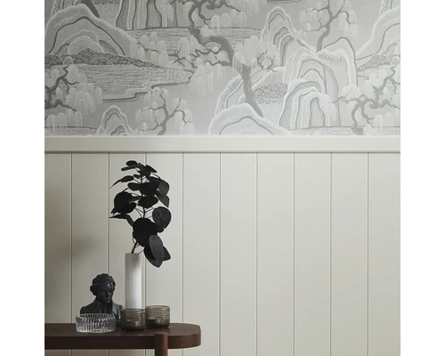 Dekorativt rum med väggpaneler, mönstrad tapet och sidobord med dekorationer