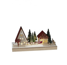 Dekorativ julscen med hus, träd och jultomten i en släde.