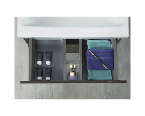 Badrumsskåp med öppen låda, med handdukar och toalettartiklar inuti