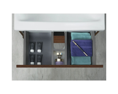 Öppen badrumslåda med handdukar och hygienprodukter
