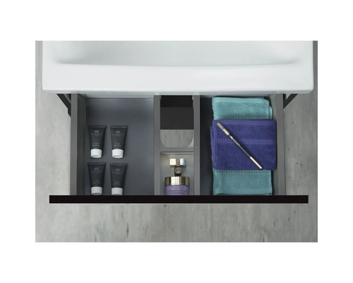 Öppet badrumsskåp med kosmetiska produkter och handdukar