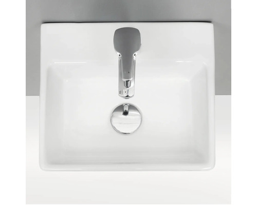 Foto av ett vitt tvättställ med kran uppifrån