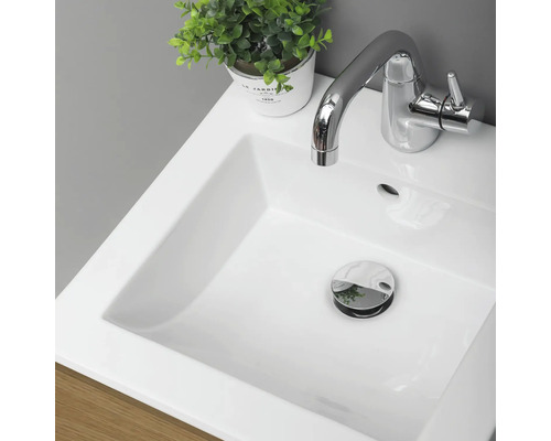 Detaljvy av ett badrumshandfat med armatur och avlopp