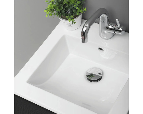 Fotografi av ett handfat med blandare och avloppsventil