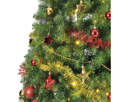 Detalj av en dekorerad julgran med bollar, stjärnor, glitter och en ljusslinga