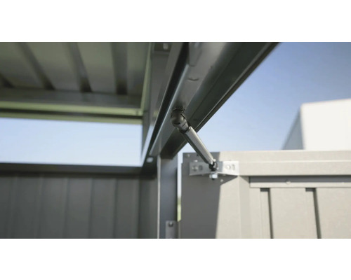 Detaljvy av en trädgårdshusdörr med gasfjäder