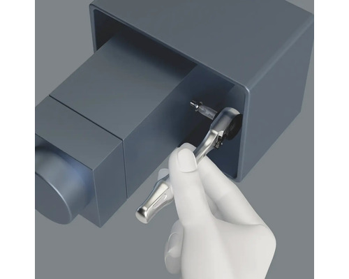 En hand använder en spärrnyckel med bits för att skruva.