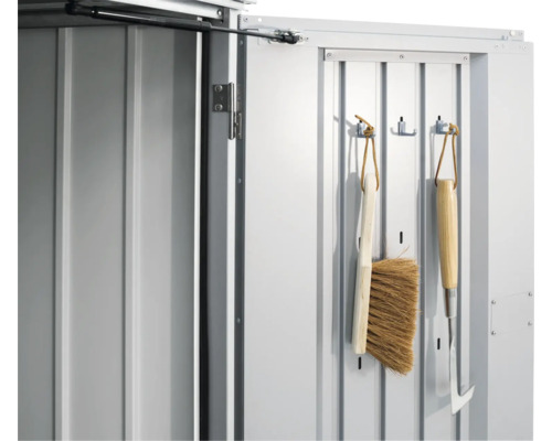 Detaljvy av en redskapsbodsdörr med trädgårdsredskap på krokar